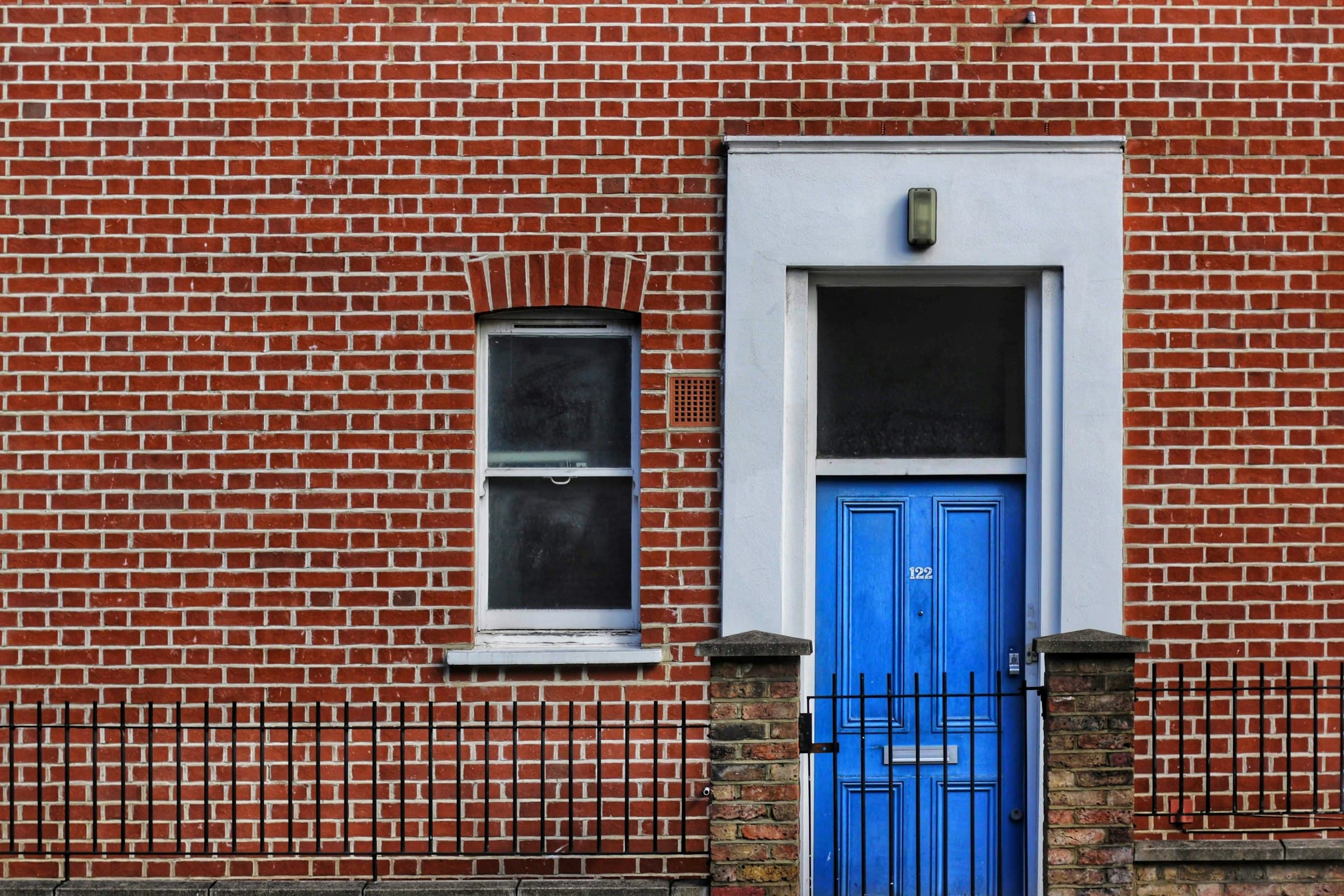 Red brick building with a blue door and window